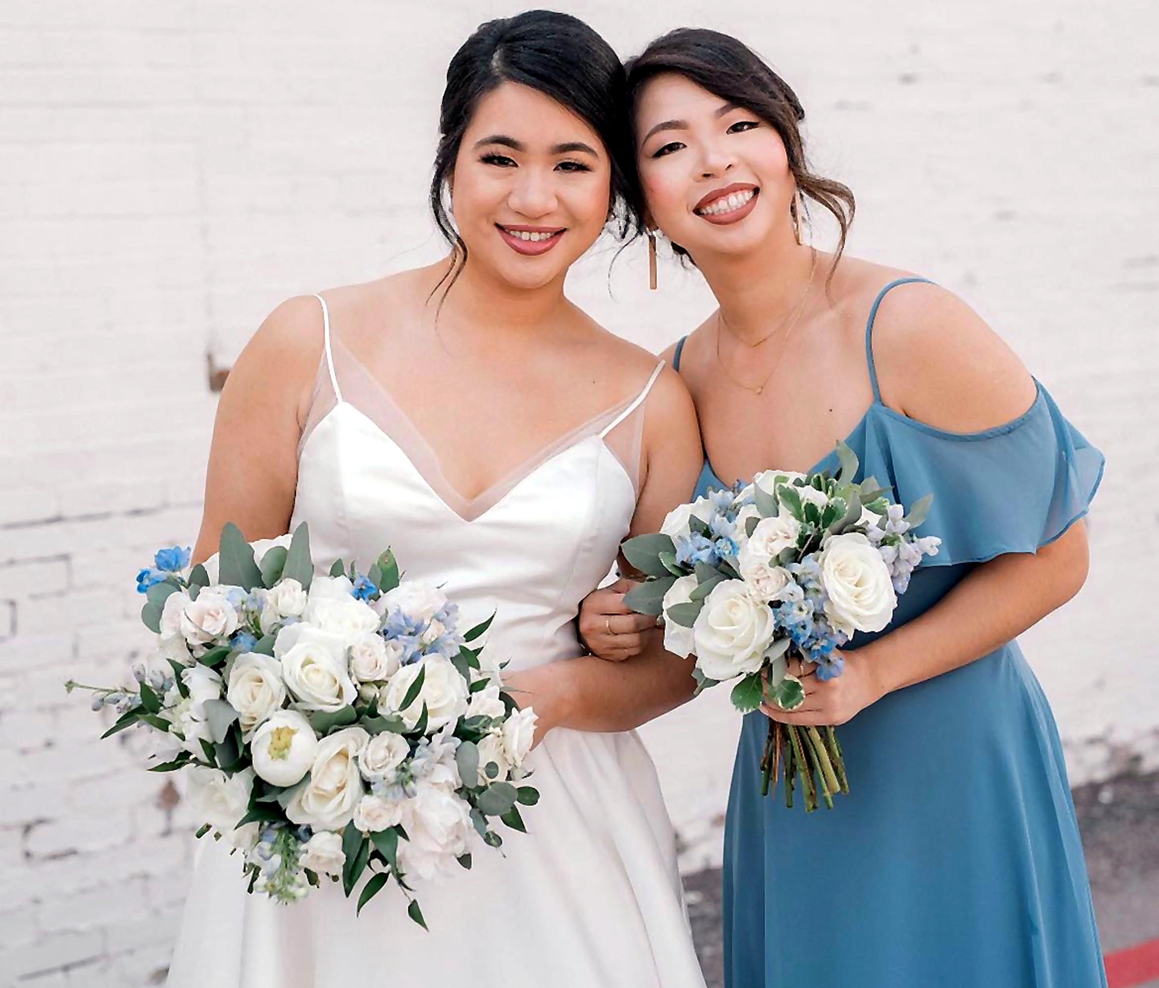 Bride and bridesmaid with bouquets, soft updos.